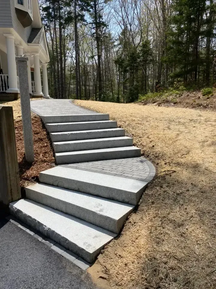 A set of concrete stairs leading up to a house.