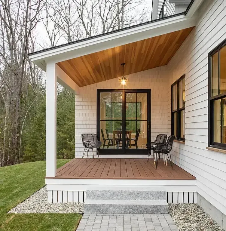 A white house with a porch and sliding glass doors