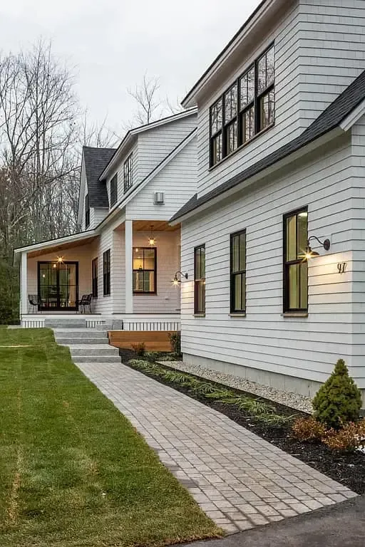 A white house with a porch and a walkway leading to it.