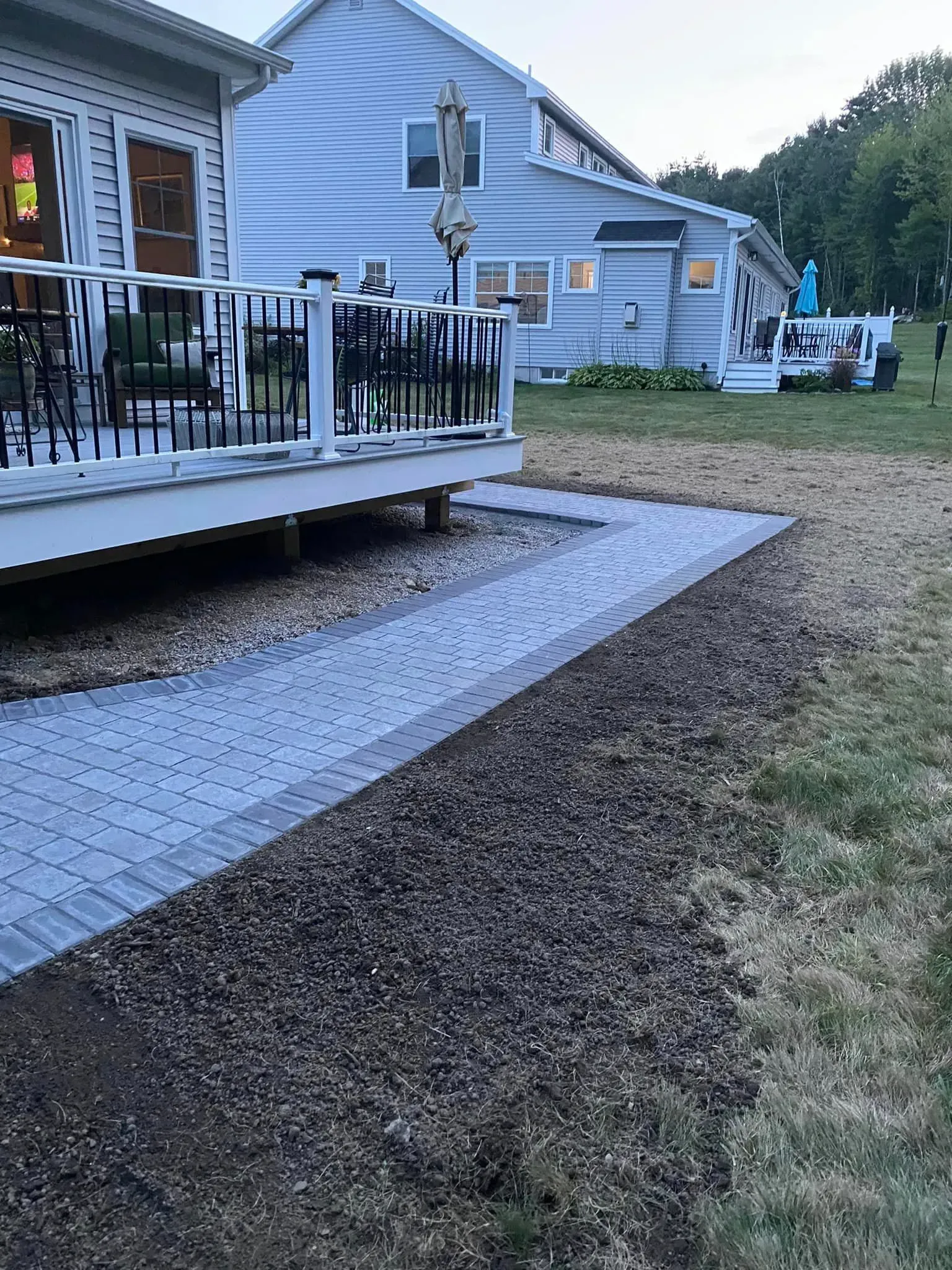 A house with a deck and a walkway in front of it.