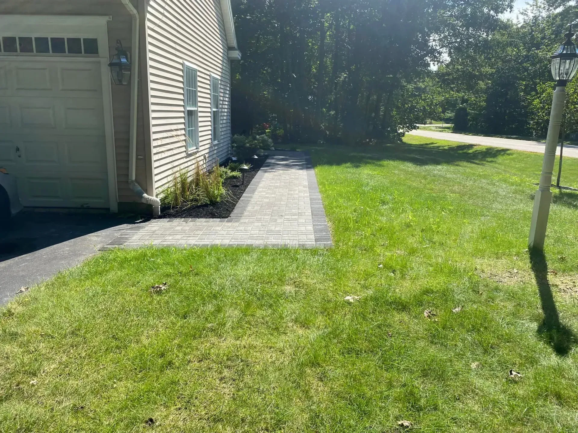 A house with a walkway leading to it and a garage.