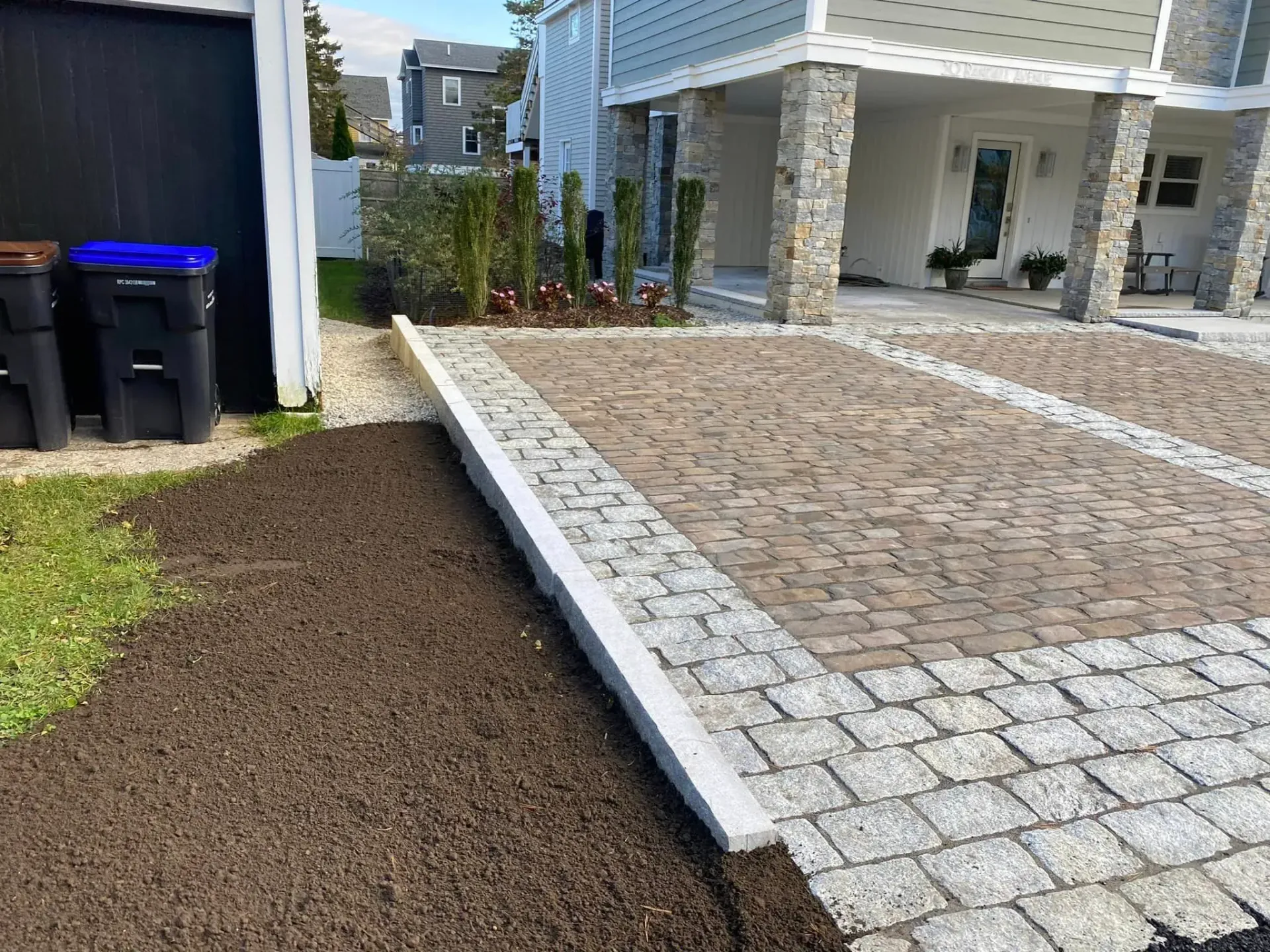A driveway with bricks and gravel in front of a house.