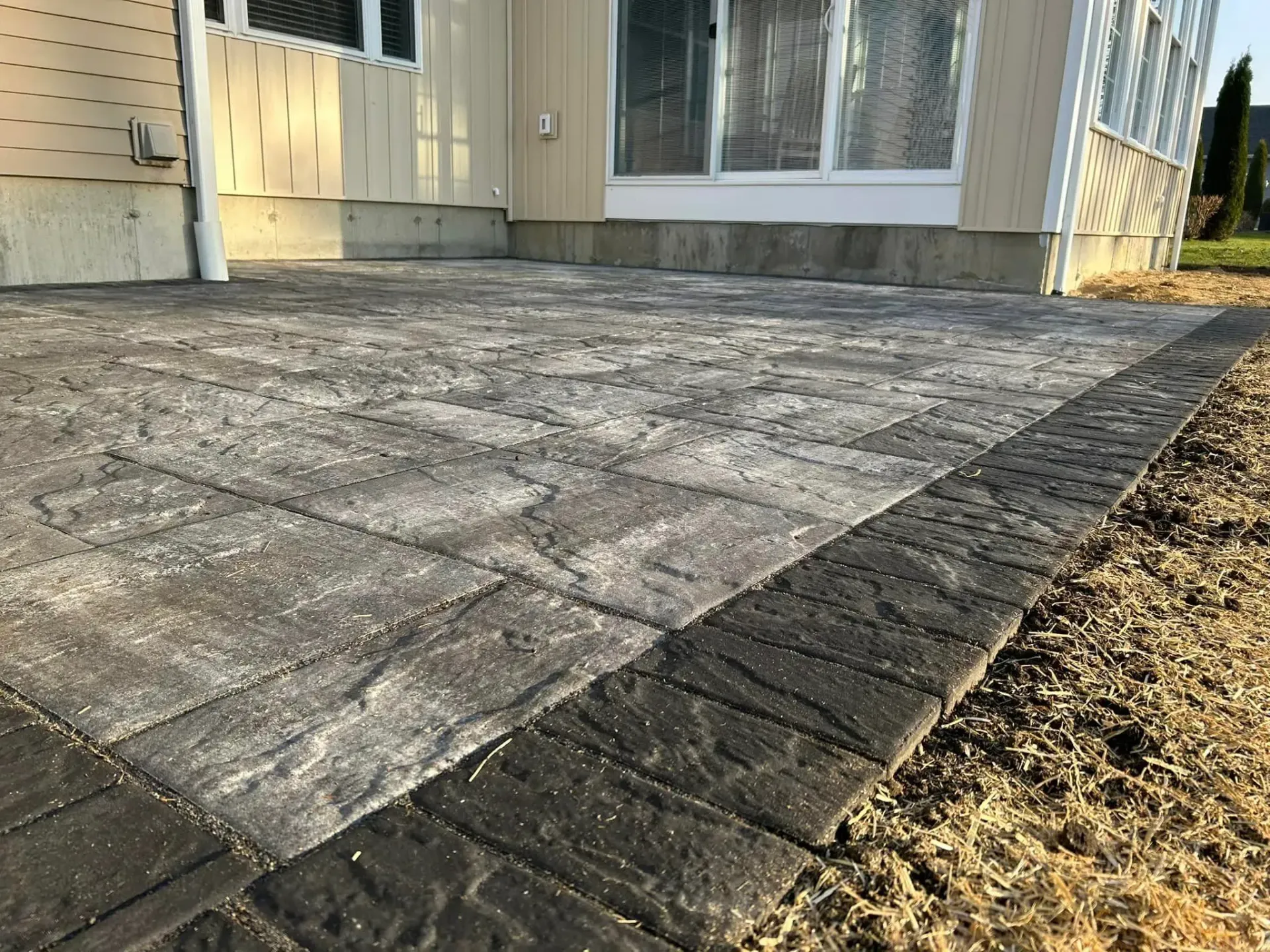 A patio is being built in front of a house.