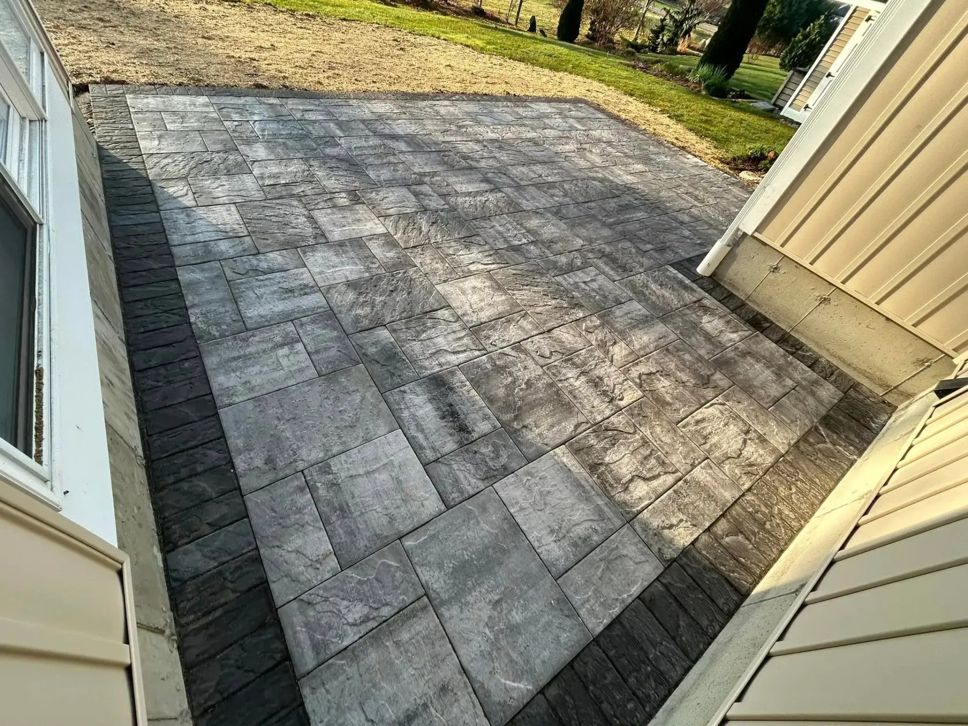 A patio is being built in the backyard of a house.
