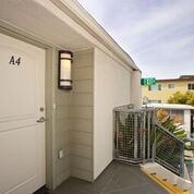 Front door of apartment on an upper level; exterior stairs lead down a flight or two