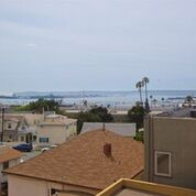 View from apartment over roofs of other buildings, the ocean is a mile or two away