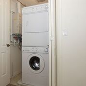 Hinged doors opening to a stacked washer and dryer