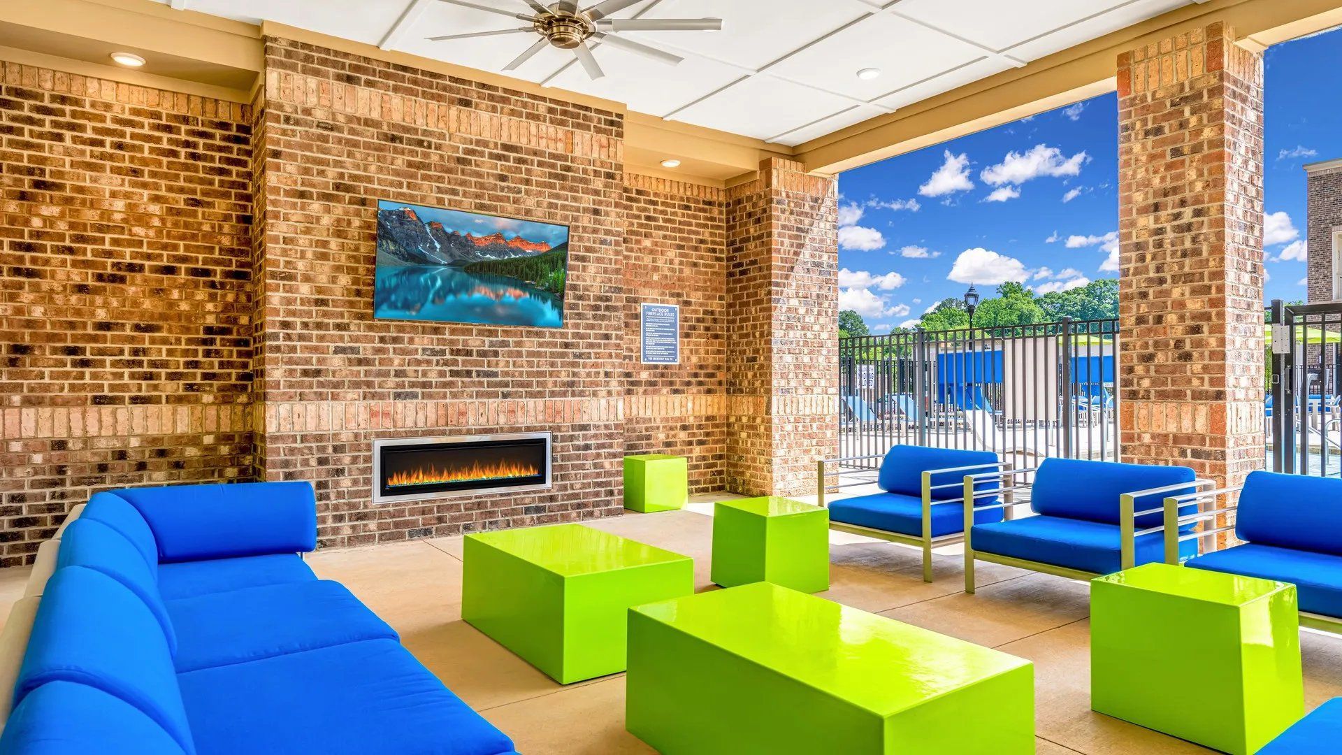 Lounge area with blue and green seating by an outdoor pool