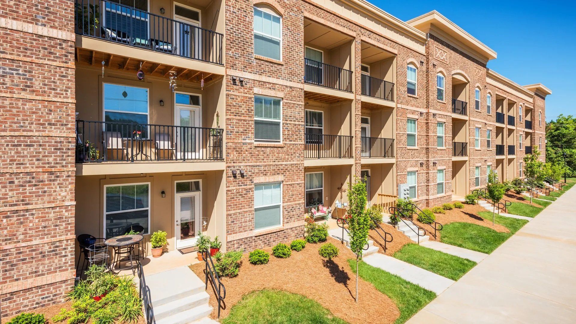 Exterior view of apartment building with balconies and landscaping.
