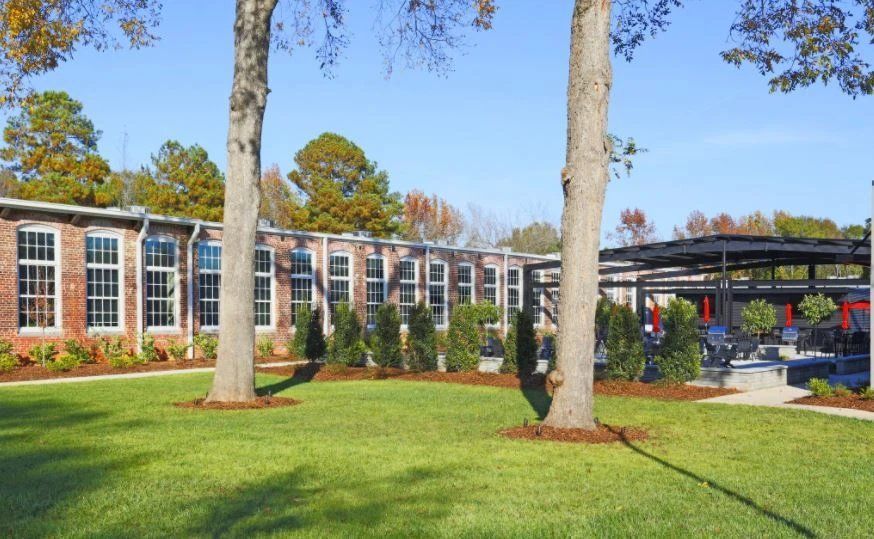 Exterior view of a property surrounded by grass and trees.