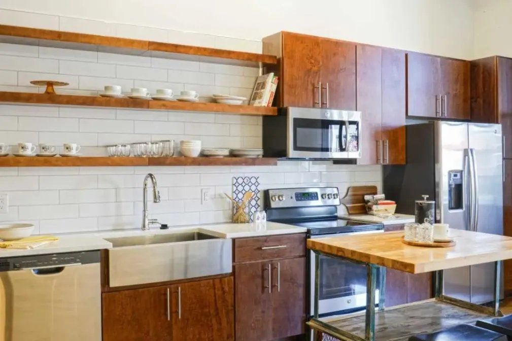 Modern kitchen with stainless steel appliances and wooden shelves