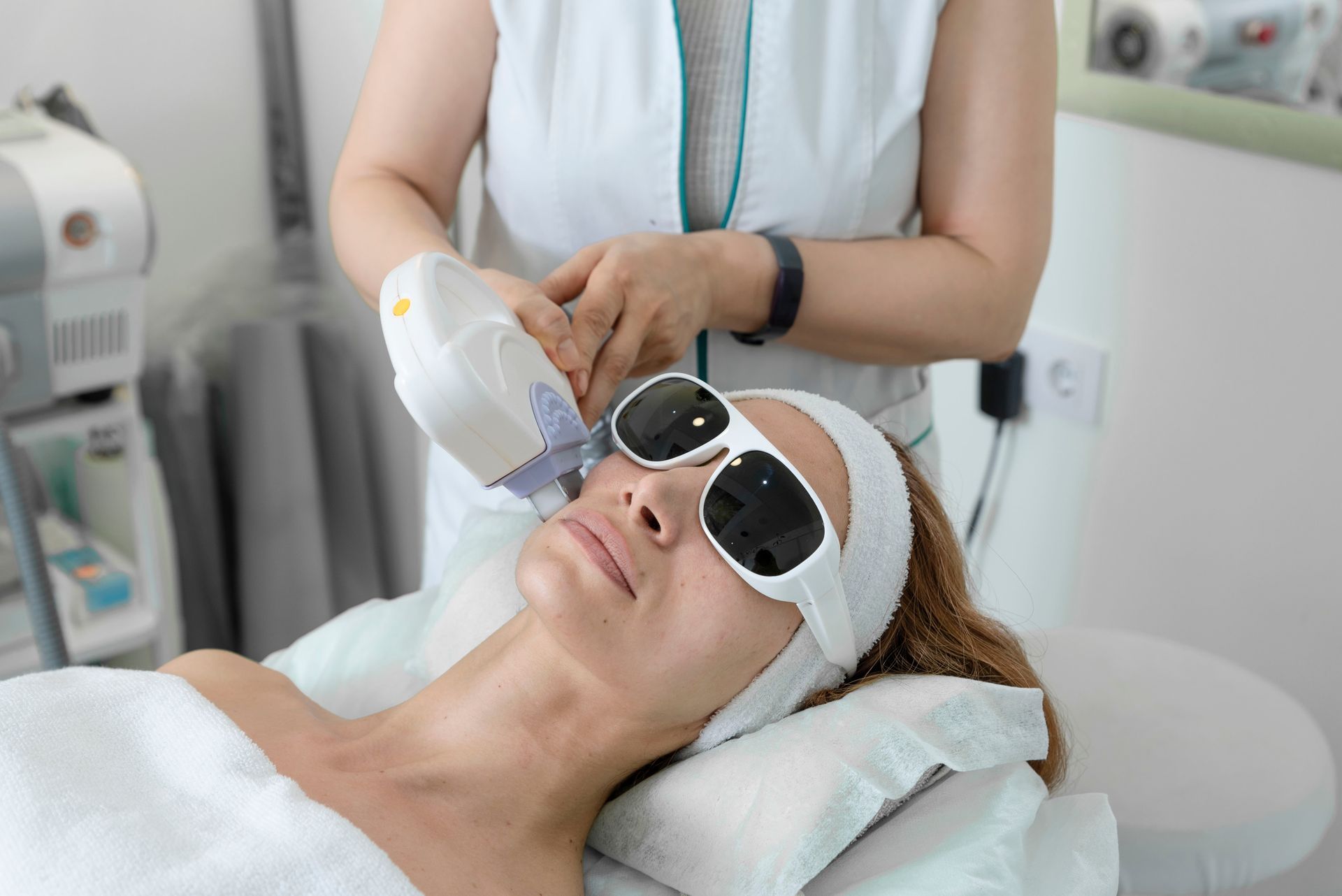 A woman is getting a laser treatment on her face.