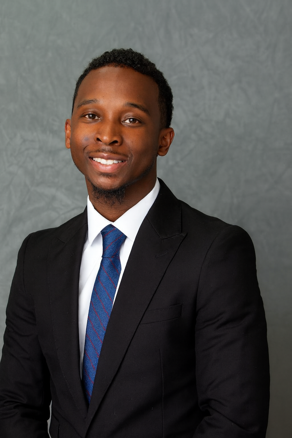 A man in a suit and tie is smiling for the camera