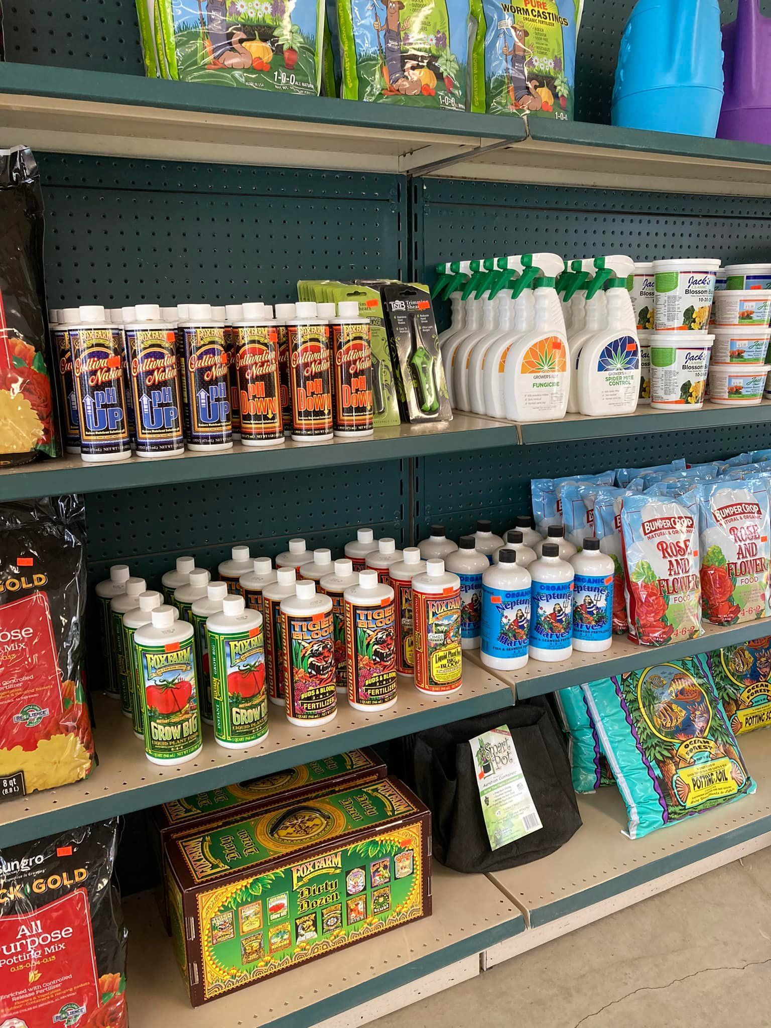 A store shelf filled with lots of bottles and bags of fertilizer.