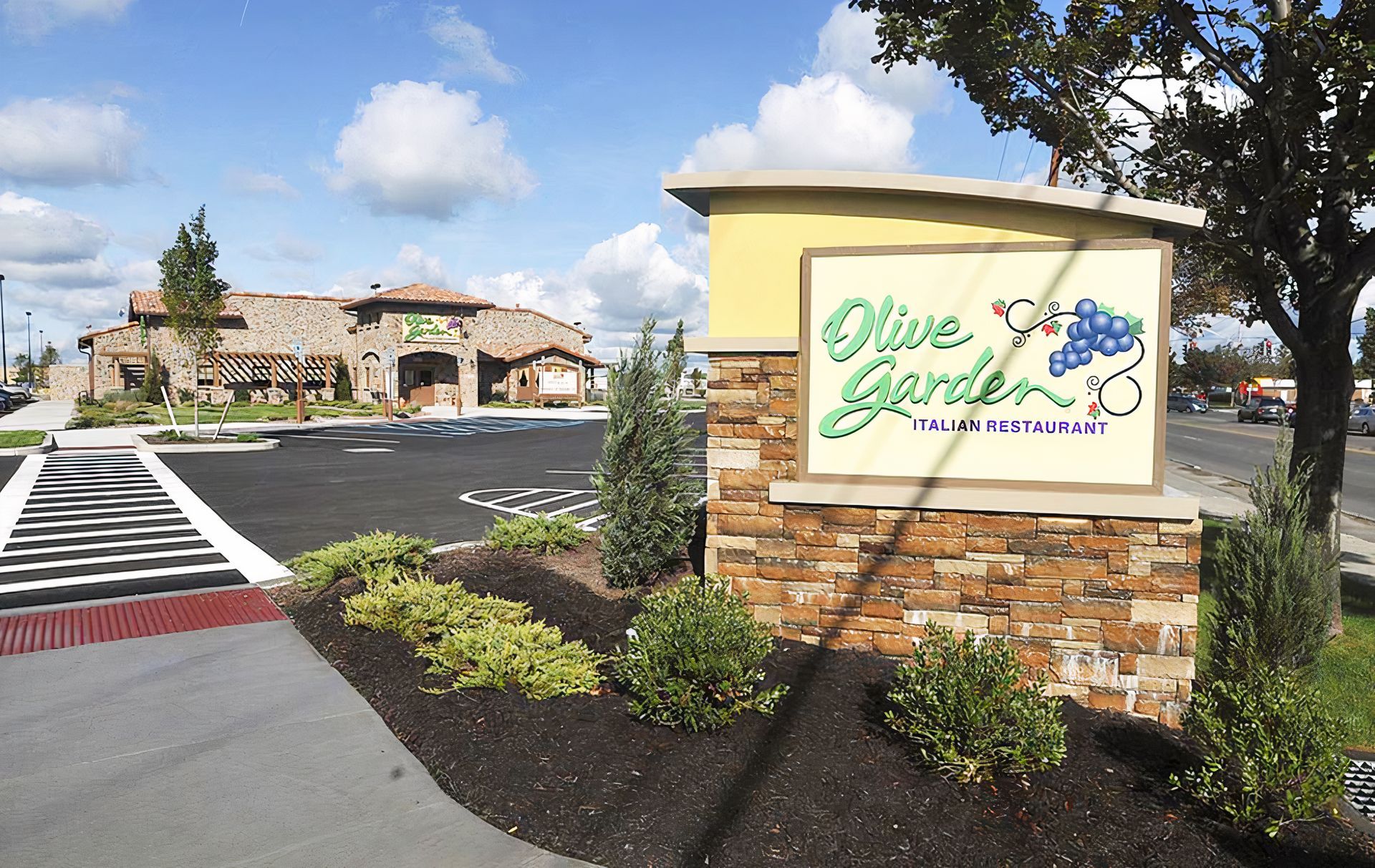 A sign that says olive garden in front of a building