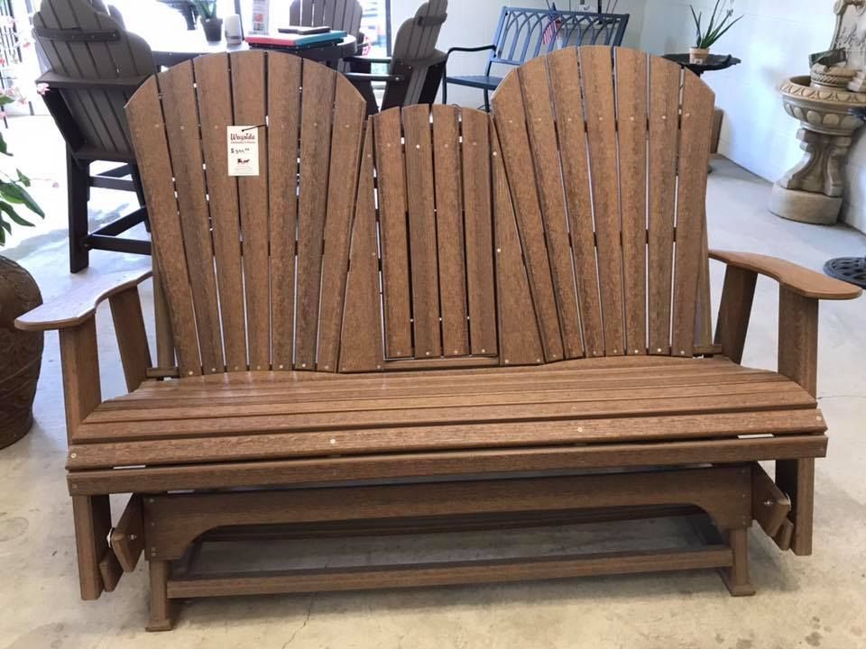 A wooden glider is sitting on a concrete floor in a room.