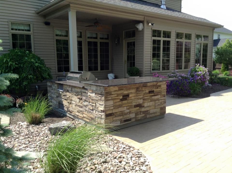 A large house with a large stone island in front of it.