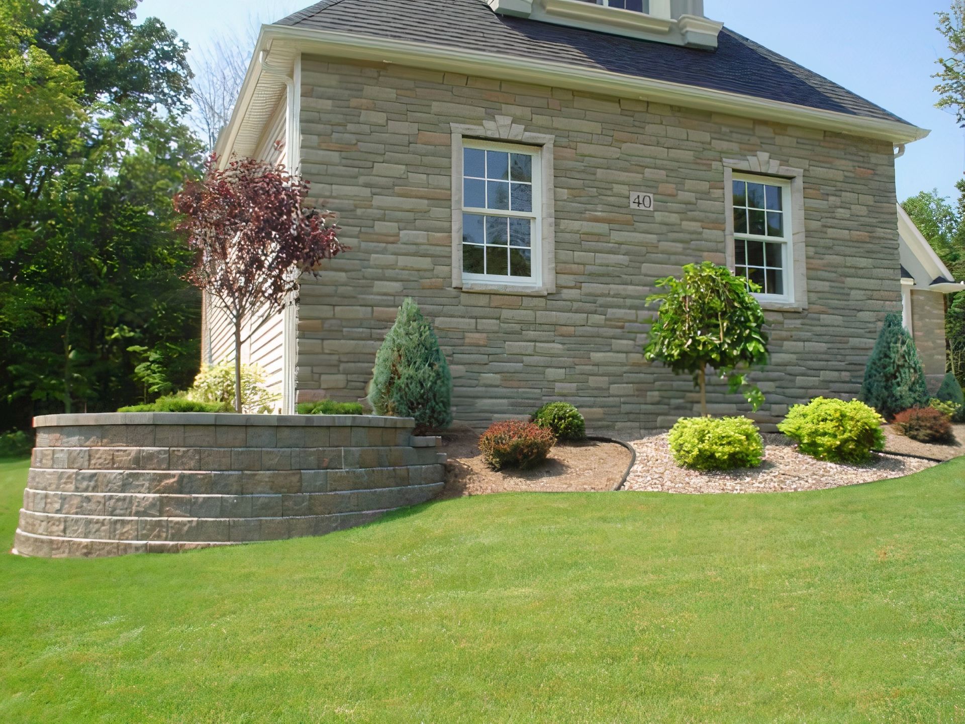 A brick house with a lush green lawn in front of it