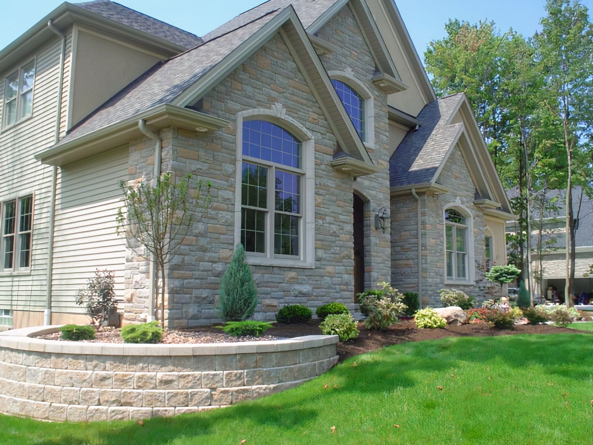 A large brick house with a lush green lawn in front of it
