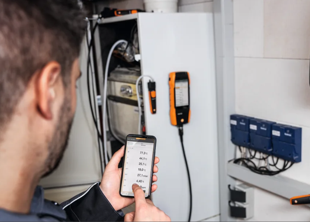 Un hombre que lleva un sombrero azul está trabajando en un aire acondicionado.