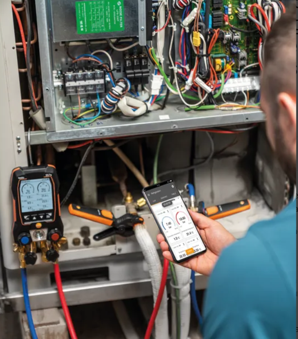 Un hombre que lleva un sombrero azul está trabajando en un aire acondicionado.