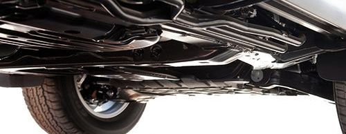 A close up of the underside of a car on a white background.