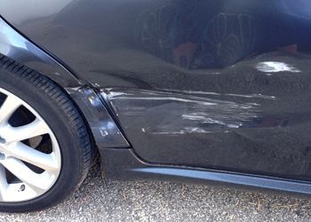 A close up of a car with a damaged side door