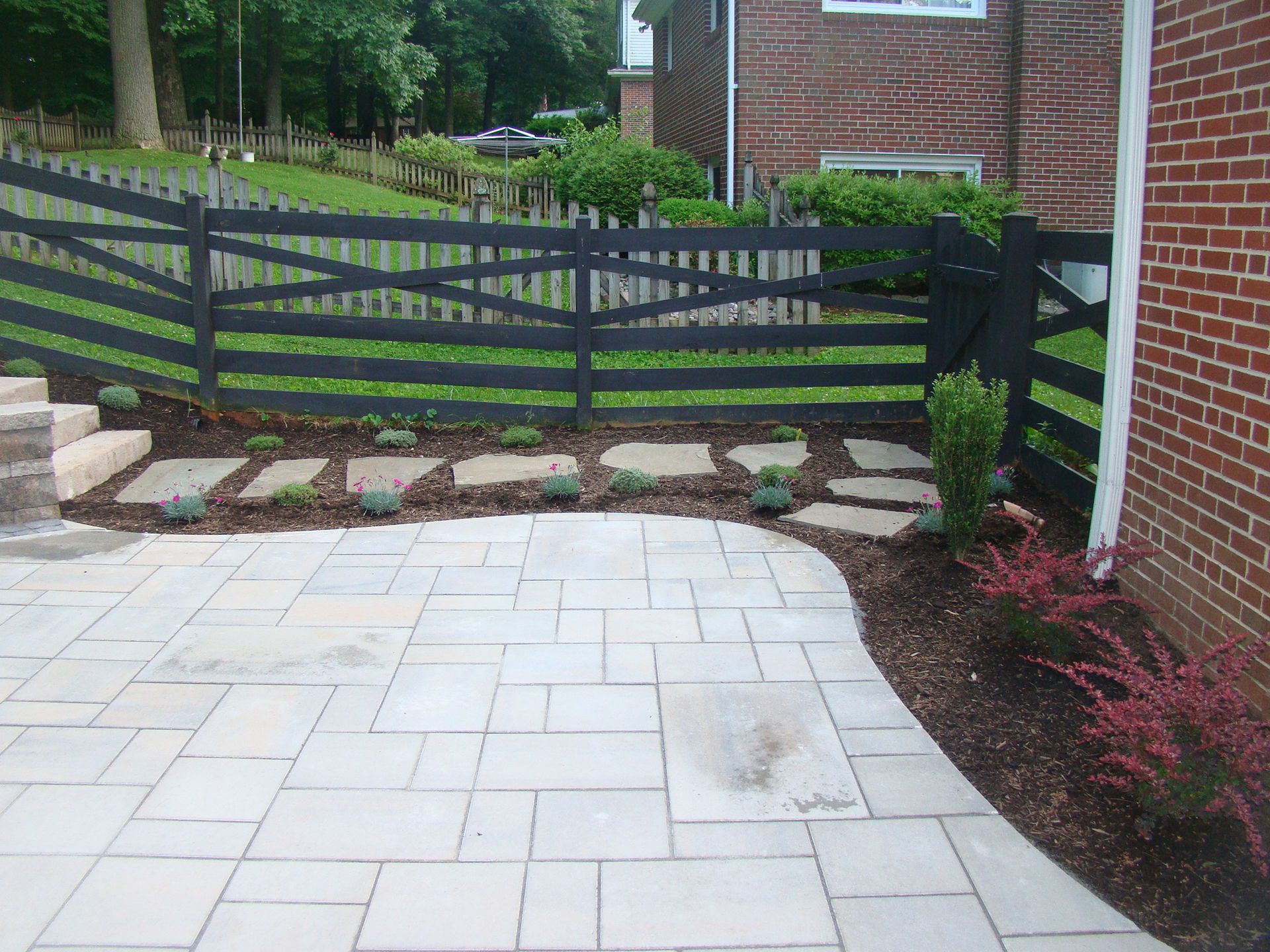 A brick house with a patio and a wooden fence