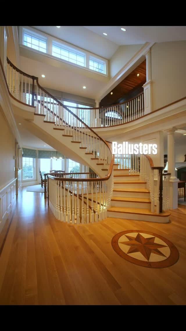 Grand foyer with curved staircase, wood floors, tall windows, and star medallion inlay