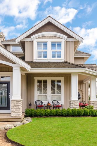 A large house with a lush green lawn in front of it.