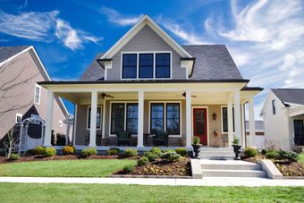 A house with a large porch and a red door