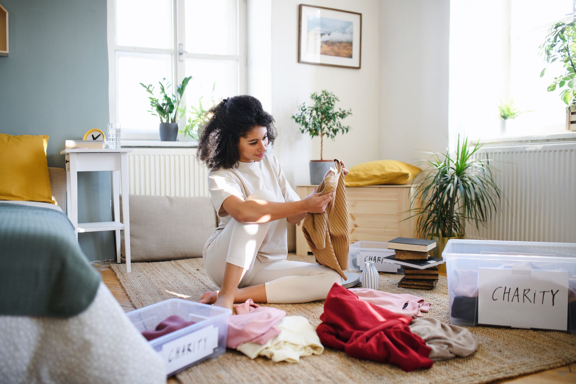 Woman sorting clothes, putting items into boxes labeled
