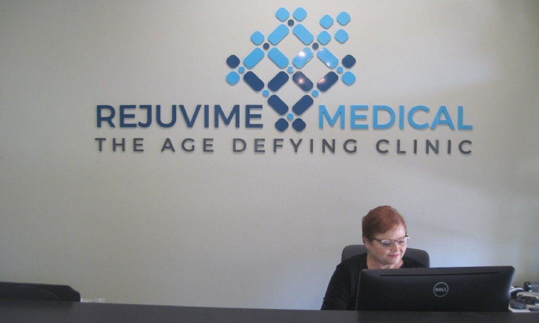 A woman sits at a desk in front of the 