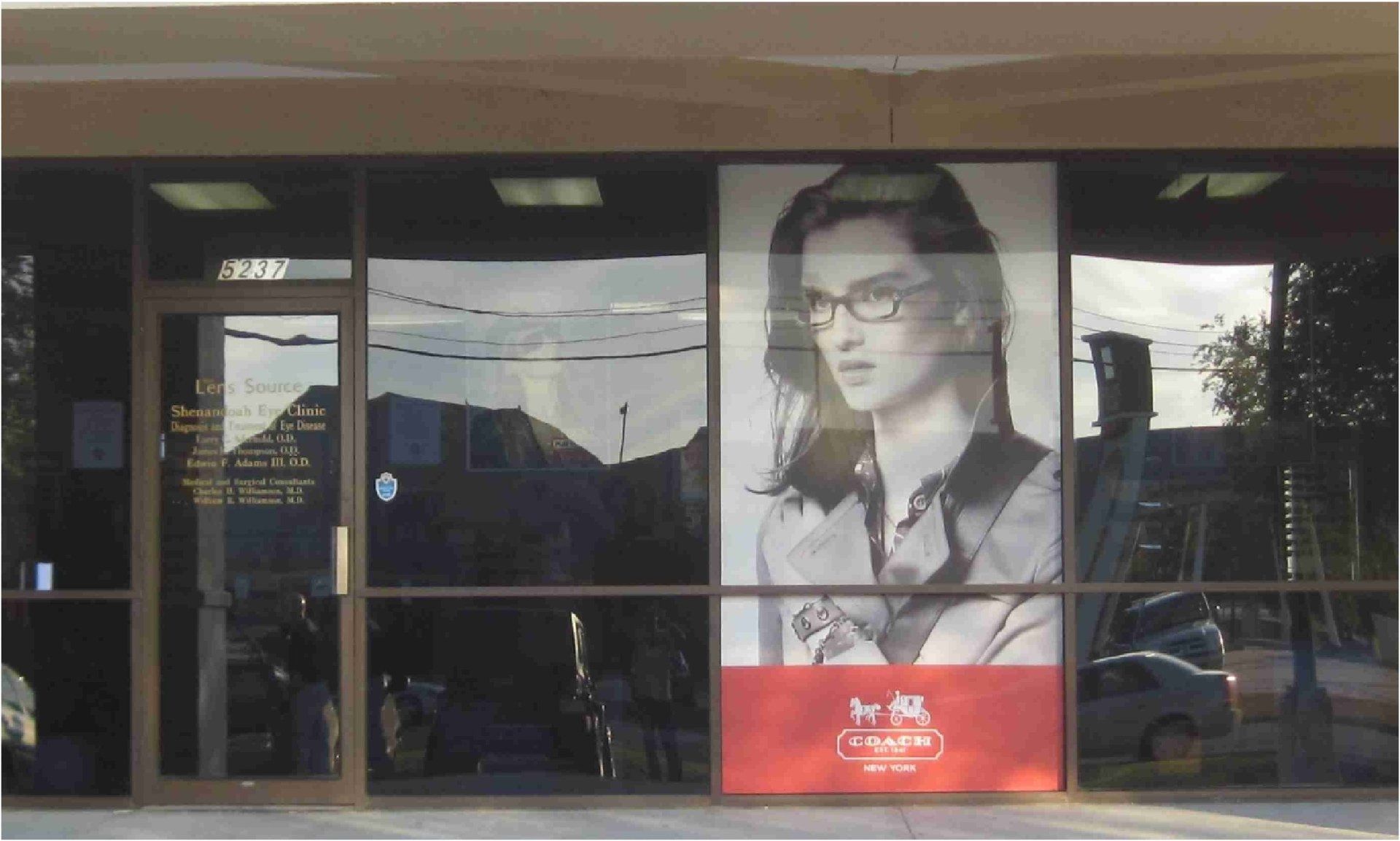 Coach eyewear storefront with a large advertisement featuring a woman wearing glasses and a red Coach logo.