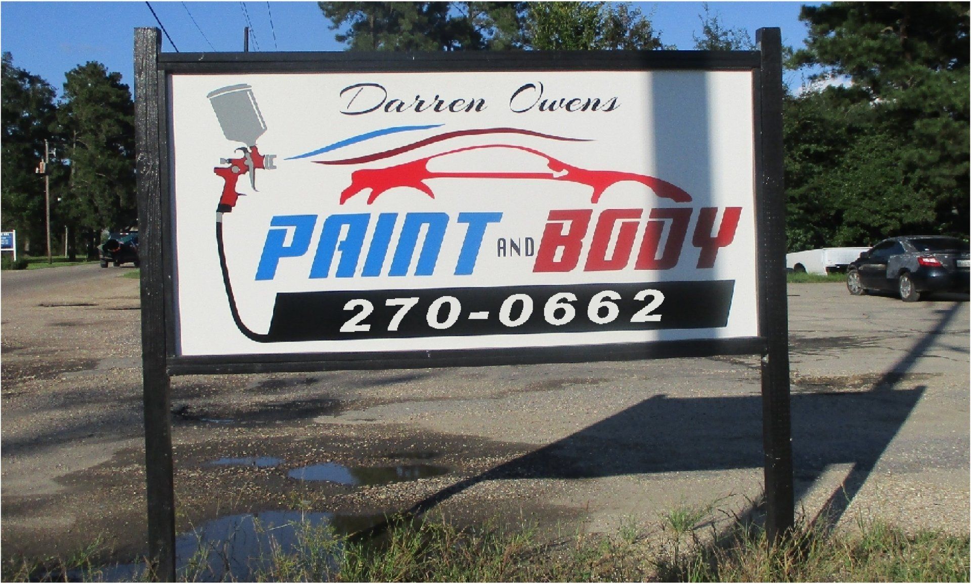 Sign for Darren Owens Paint and Body, featuring a car graphic, spray gun, and phone number.