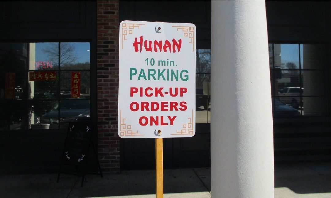 Sign for Hunan restaurant: white sign with red and green text, stating 