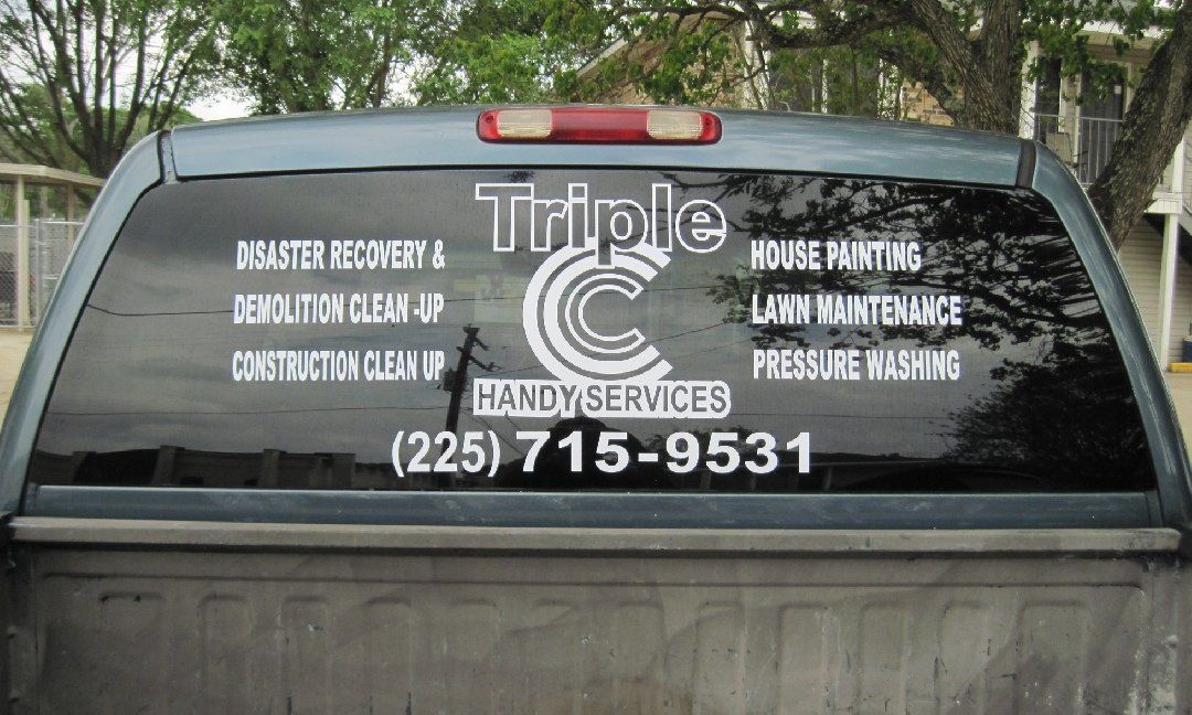 Rear window of a pickup truck with white text advertising 