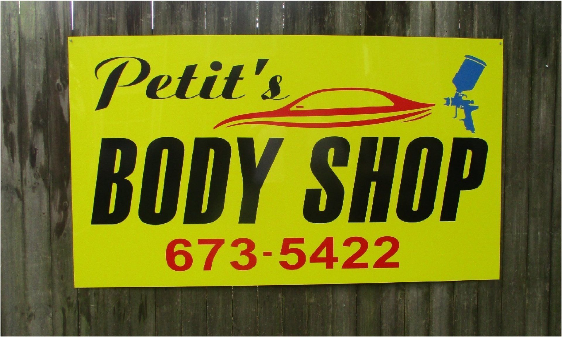 Yellow sign for Petit's Body Shop with black text and red phone number 673-5422; includes a car outline and paint gun graphic.