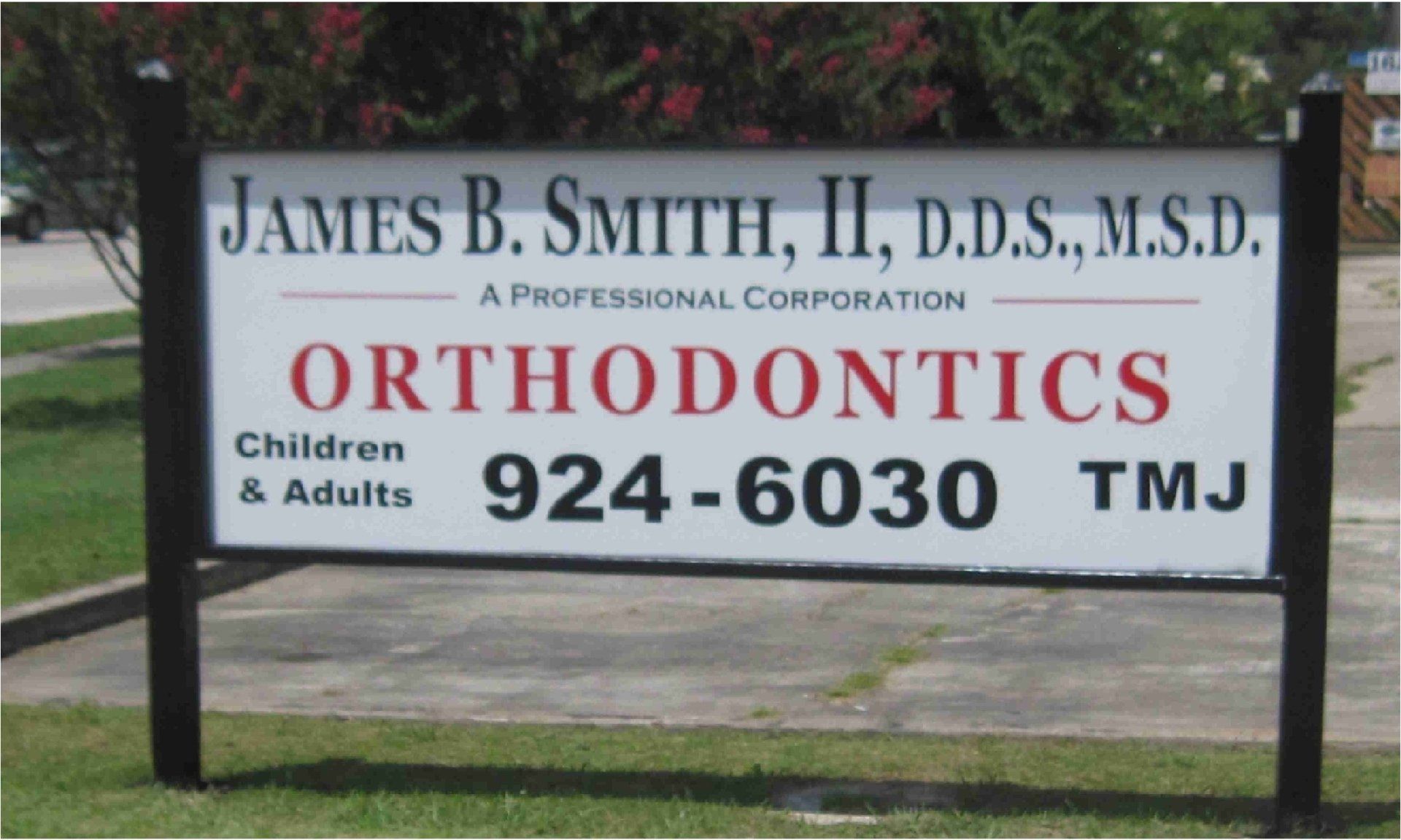 Sign for James B. Smith, II, D.D.S., M.S.D., Orthodontics office. Displays name, services offered, and phone number (924-6030).