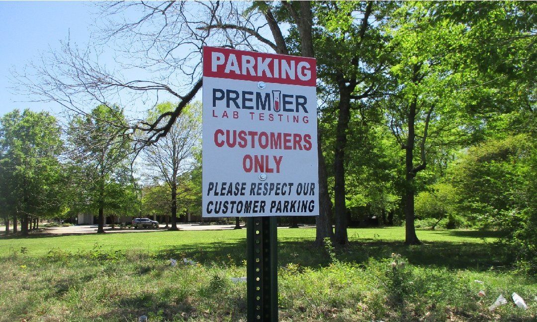 Parking sign for Premier Land Tech: Red and white sign reading 