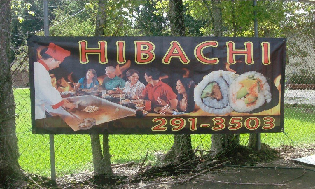 Sign for a Hibachi restaurant. It features a chef cooking and patrons dining, along with sushi rolls, all against a dark background.