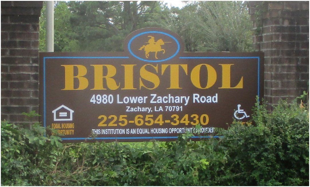Sign for Bristol apartments, brown with yellow text, a horse logo, address, phone number, and accessibility icons.