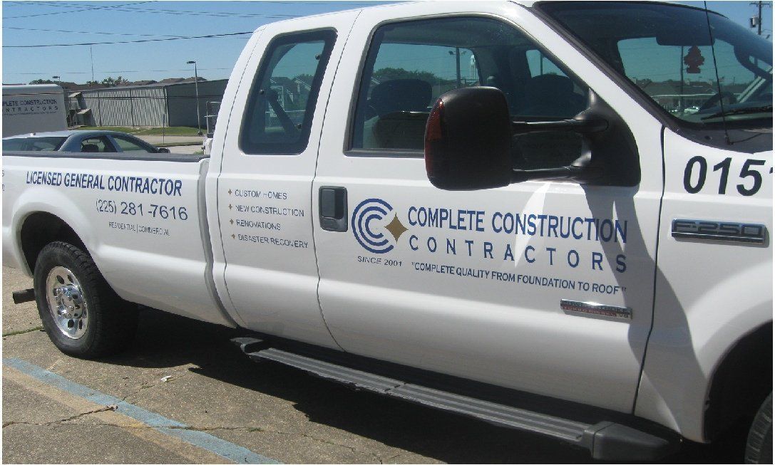 White Complete Construction Contractors truck parked outside with company logo and contact information.