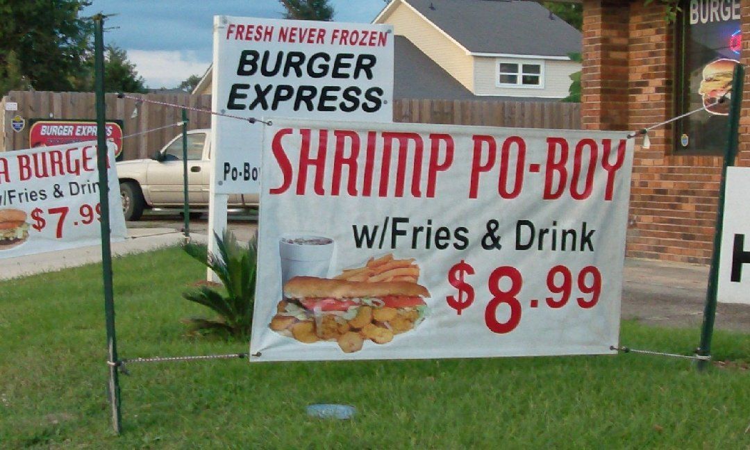 Signs advertising a burger and shrimp po-boy at a restaurant called Burger Express. Prices are $7.99 and $8.99 respectively.