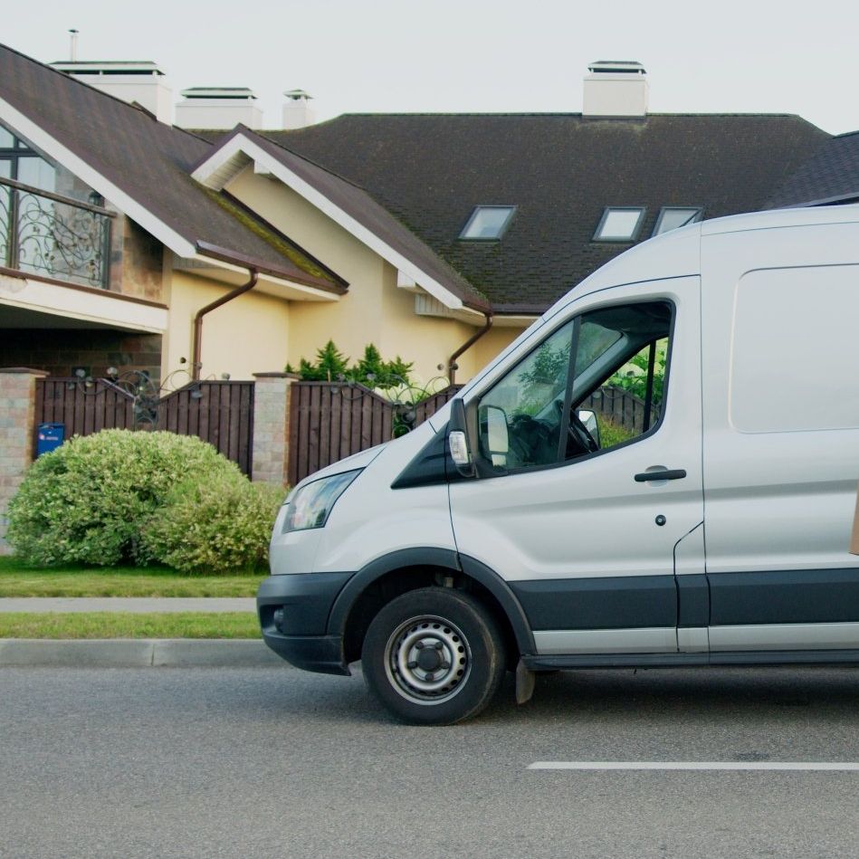 Ein weißer Lieferwagen steht vor einem Haus