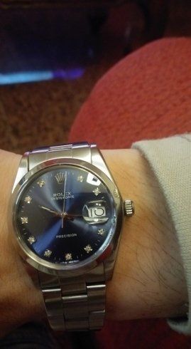 polso con orologio rolex con quadrante blu