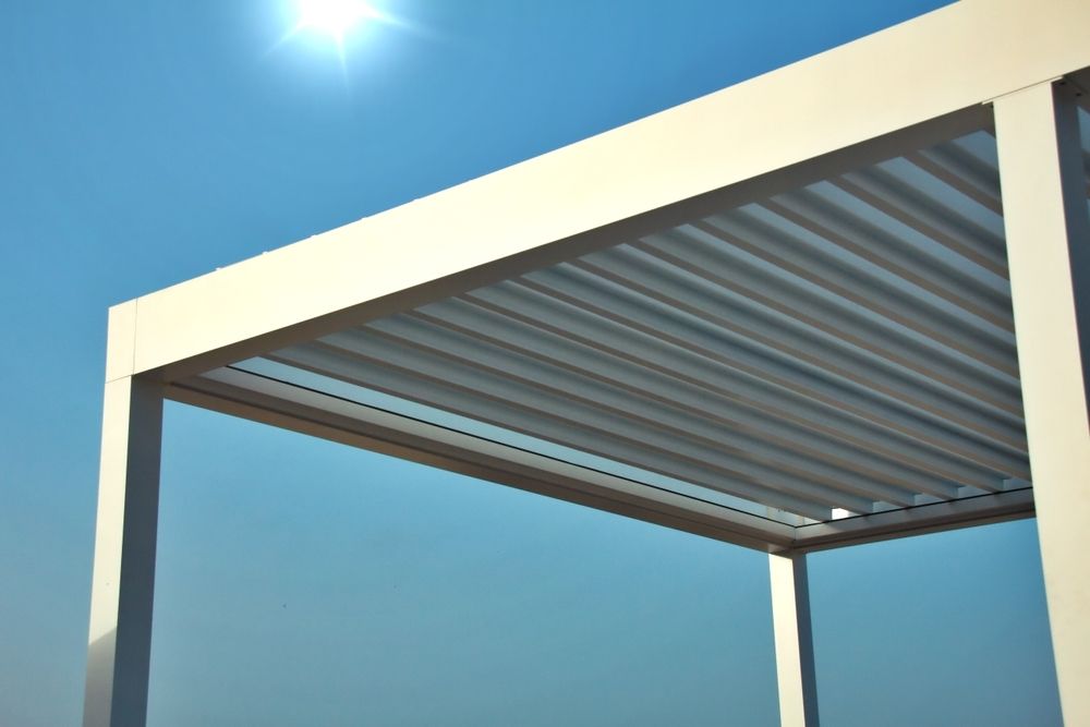 A white pergola with a blue sky in the background
