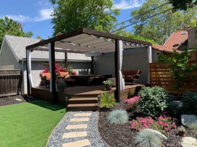 There is a pergola in the backyard of a house.