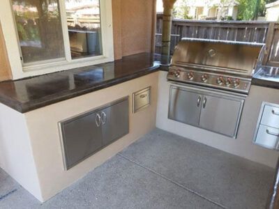 A kitchen with stainless steel cabinets and a grill