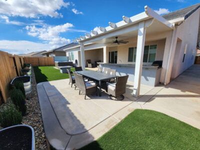 A patio with a table and chairs under a pergola.